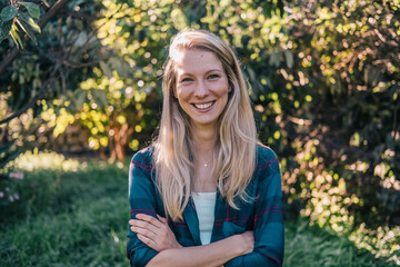 Portrait of a smiling young Caucasian woman in a natural setting.