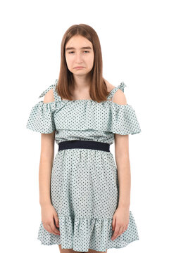 Young beautiful girl in a blue dress with polka dots on a white background