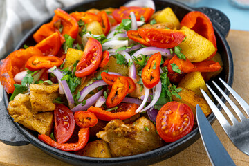 Pork ojakhuri with vegetables. Meat, potatoes, onions, herbs, peppers cooked and served in a skillet. A dish of Georgian cuisine. Meat food, lunch, dinner on the table