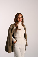 Elegant young woman in brown jacket standing over with background. Fashion studio photo, Autumn and Winter concept