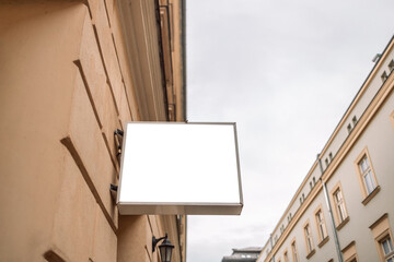 Blank sign outside a shop or restaurant with copy space in old city street. Blank signboard outdoors.