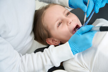 Obraz na płótnie Canvas Stomatologist treating dental caries in little patient