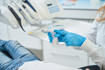 Dentist in nitrile gloves preparing client for local anesthesia