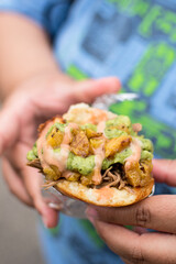Biracial woman eating a arepa at the state fair