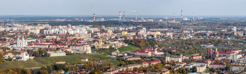 ariel panoramic view of old city and modern skyscrapers with a huge factory with smoking chimneys...