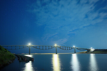 薄雲が広がる夜空と川にかかる橋