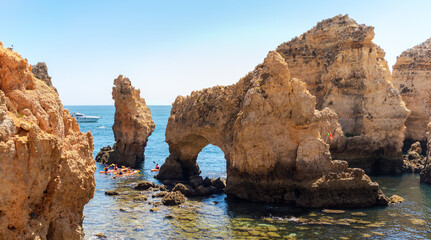 Tourists on a kayak visiting the limestone rocks by the sea at Ponta da Piedade headland, Algarve, Portugal