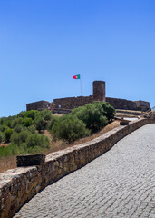 Portugal, August 2022: Aljezur castle with Portuguese flag in Algarve, Portugal, vertical picture
