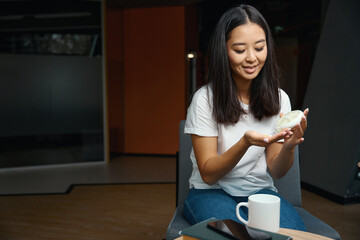 Beautiful Asian female is sitting on the chair in the modern office