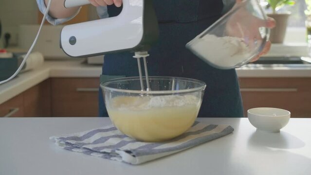 woman in the kitchen mixing ingredients and flour for cake