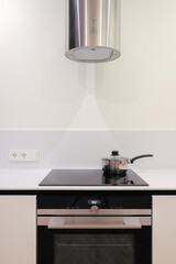 Frying pan on electric induction cooker in kitchen