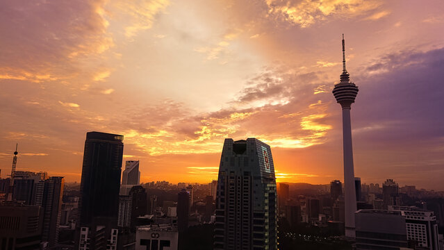 KL Tower, can be seen against the backdrop of a sunset.