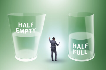 Businessman in half empty half full glass concept