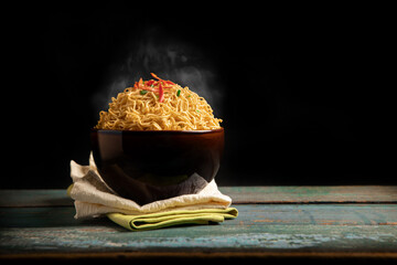 Bow of Hot Boiled Instant Noodles with Stream on the Table. Fast food Concepts. Side View with more...