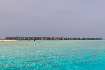 Panorama of Water Villas (Bungalows) and wooden jetty at Tropical beach in the Maldives at summer day