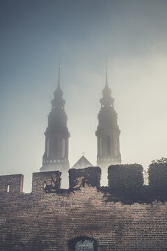 wieże katedry opolskiej we mgle za murami miejskimi