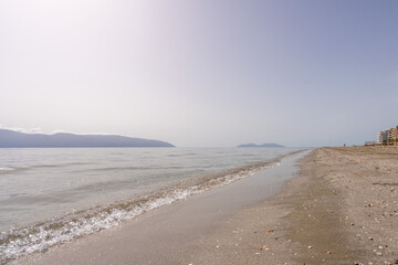 Soft blue sea wave on clean sandy beach in Vlore, Albania