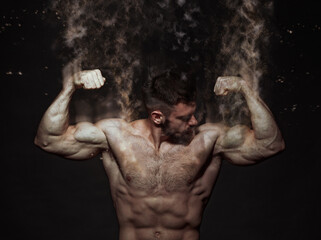 Muscle shirtless bodybuilder flexing his biceps, disintegrating into particles, dramatic image - 540252803