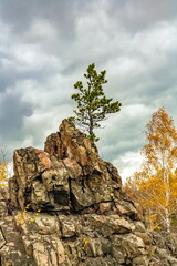 Autumn landscape with rocks, trees and sky with clouds