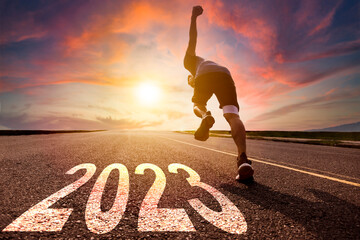 Young man running and sprinting on the road with new year 2023 concept - obrazy, fototapety, plakaty
