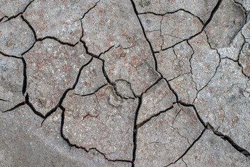 The ground has cracks in the photo from above for a background or graphic design with the concept of drought and death.