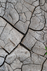 The ground has cracks in the photo from above for a background or graphic design with the concept of drought and death.