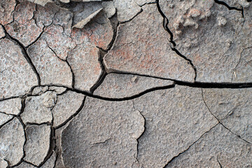 The ground has cracks in the photo from above for a background or graphic design with the concept of drought and death.