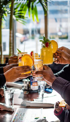 Black people, African Americans, Black families celebrating  with a tropical cocktail toast in a restaurant - obrazy, fototapety, plakaty