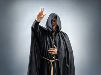 Catholic monk is preaching. Photo of a man wearing a monk robe. Concept for faith, spirituality and religion