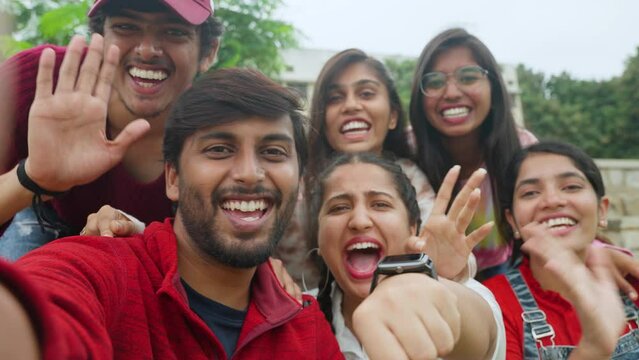 Group of cheerful excited young happy friends making video call by looking camera - concept of bonding, togetherness and enjoyment.