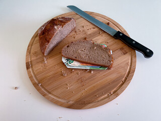 Banknotes between two slices of bread represent exploding inflation and the associated rising...