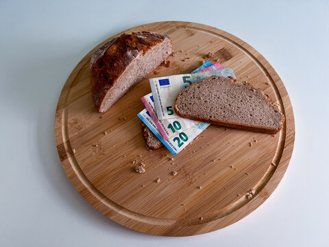 Banknotes between two slices of bread represent exploding inflation and the associated rising prices for everyday goods such as bread and other foodstuffs 