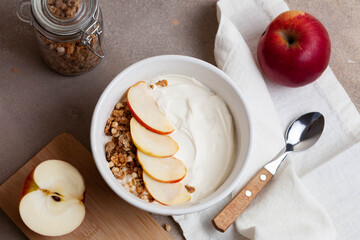 Healthy breakfast of apples, granola and yogurt