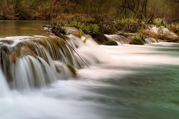 Blurred fast flowing water in Krka river waterfalls, cascading stones