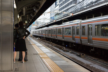 JR名古屋駅ホームにいる女性の後ろ姿と旅行用のスーツケース