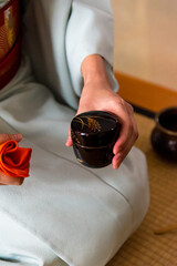 Japanese woman, tea master, Sen Rikyu, hands using a purifying cloth to clean a Natsume lacquered wooden matcha tea container in Japanese traditional tea ceremony © A Certain Aesthetic