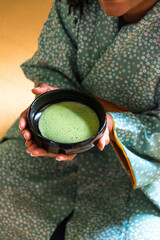 Black woman hands preparing to drink matcha tea during Japanese traditional tea ceremony 