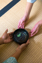 Black woman hands returning chawan tea bowl to Japanese woman, tea master, Sen Rikyu hands after drinking matcha tea during Japanese traditional tea ceremony  © A Certain Aesthetic