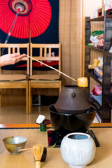 Japanese woman, tea master, Sen Rikyu, hands ritual preparing to lay down Hishaku bamboo ladle on...