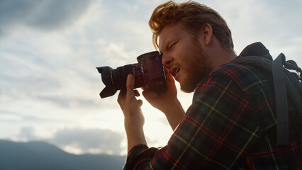 Fototapeta na wymiar Closeup professional photographer take camera photo on sunset mountains nature.
