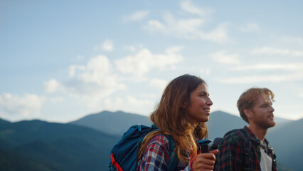 Closeup happy hikers walk summer mountains. Smiling couple backpack in nature