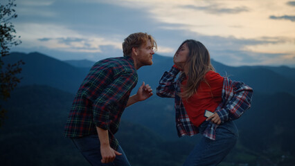 Dancing couple have fun in mountains evening. Happy lovers enjoy sunset outdoors
