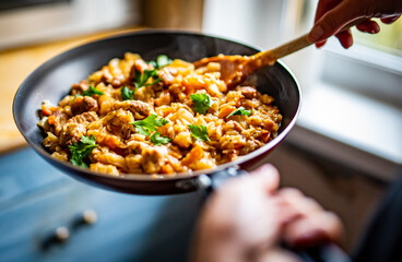 Woman cooking tasty Stew with meat and cabbage in pan on kitchen