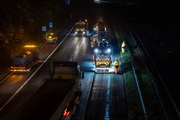 Tuinposter High angle view of road resurfacing work at night © Into The Light