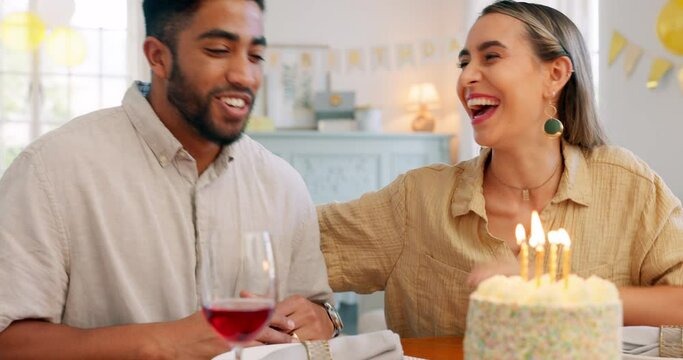 Couple, birthday and cake with kiss, blowing candles and hug, smile and clapping at a party in home. Happy latino man and woman with celebration, surprise and gift with romance, love and happiness