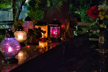 colorful candles on the cemetery on the grave at night, all Saints Day