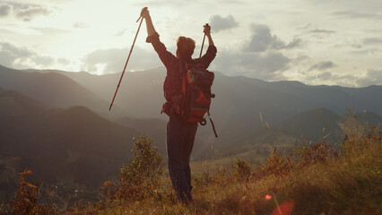 Cheerful traveler celebrate freedom outdoors. Young trekker hike mountains hill.