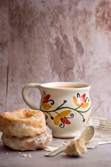 Café con leche en taza pintada a mano y rosquillas