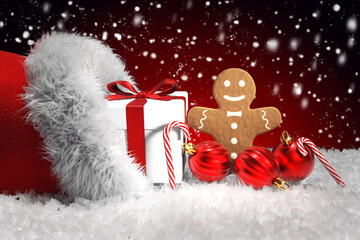 Weihnachtsmütze mit Geschenk, Lebkuchen, Weihnachtskugeln und Zuckerstangen, roter Hintergrund mit...