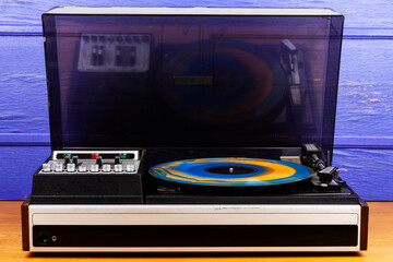 Vintage turntable vinyl record player with blue and orange vinyl